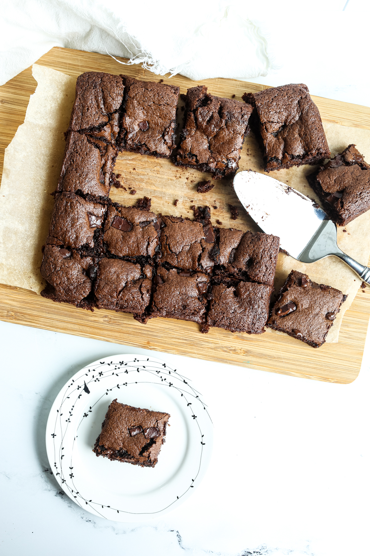 chocolate tahini brownies on a cutting board with one on a plate