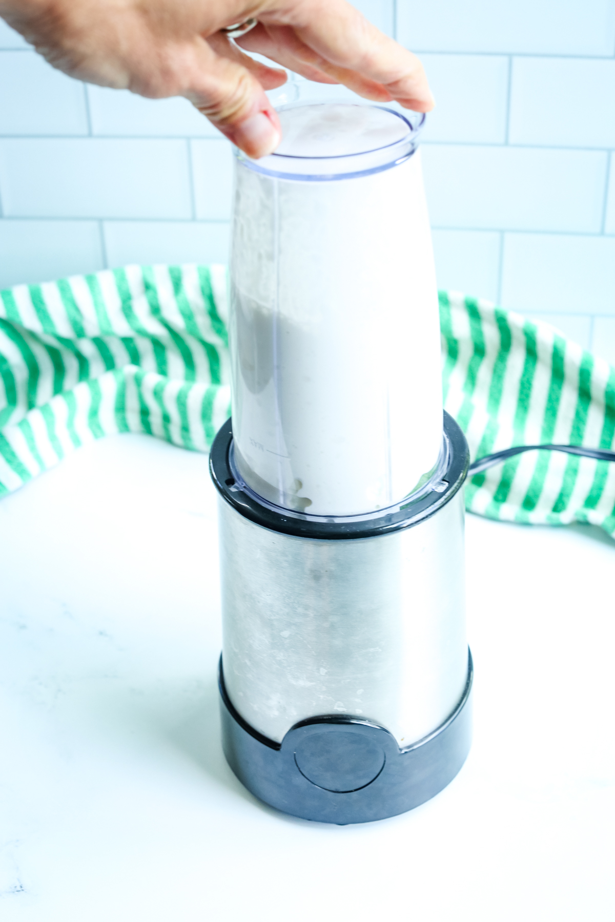 a small blender with a hand blending it