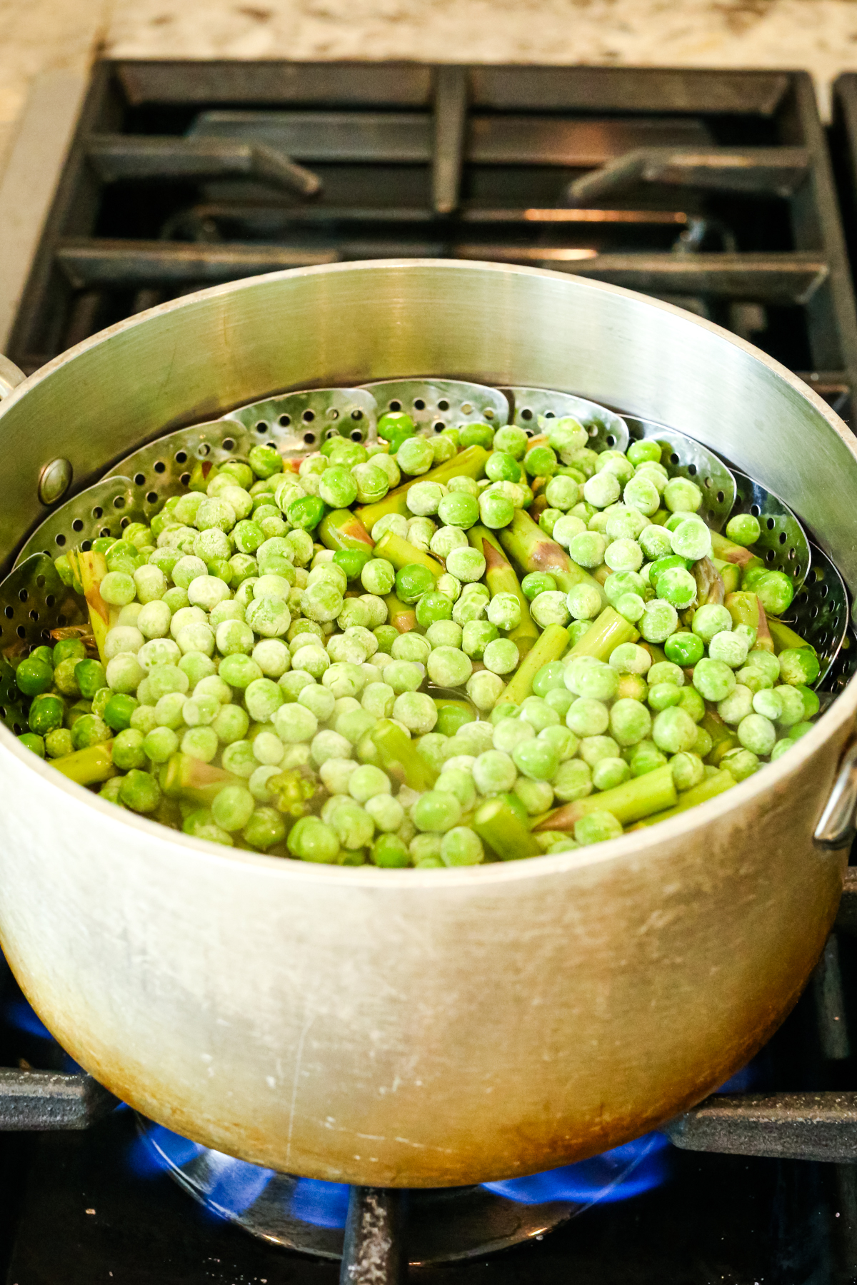 steaming a pot of asparagus and peas