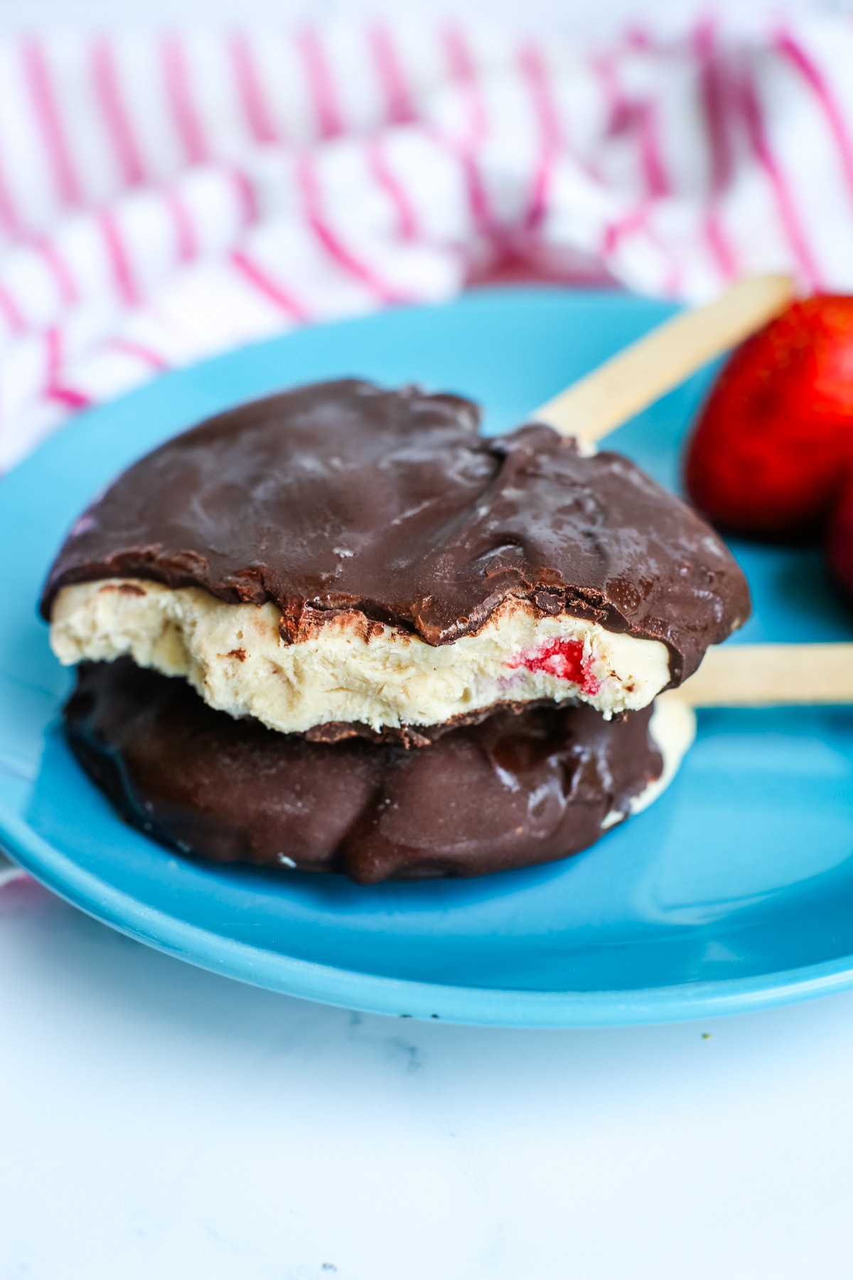 two frozen greek yogurt bars stacked on top of each other with the top one having a bite out of it
