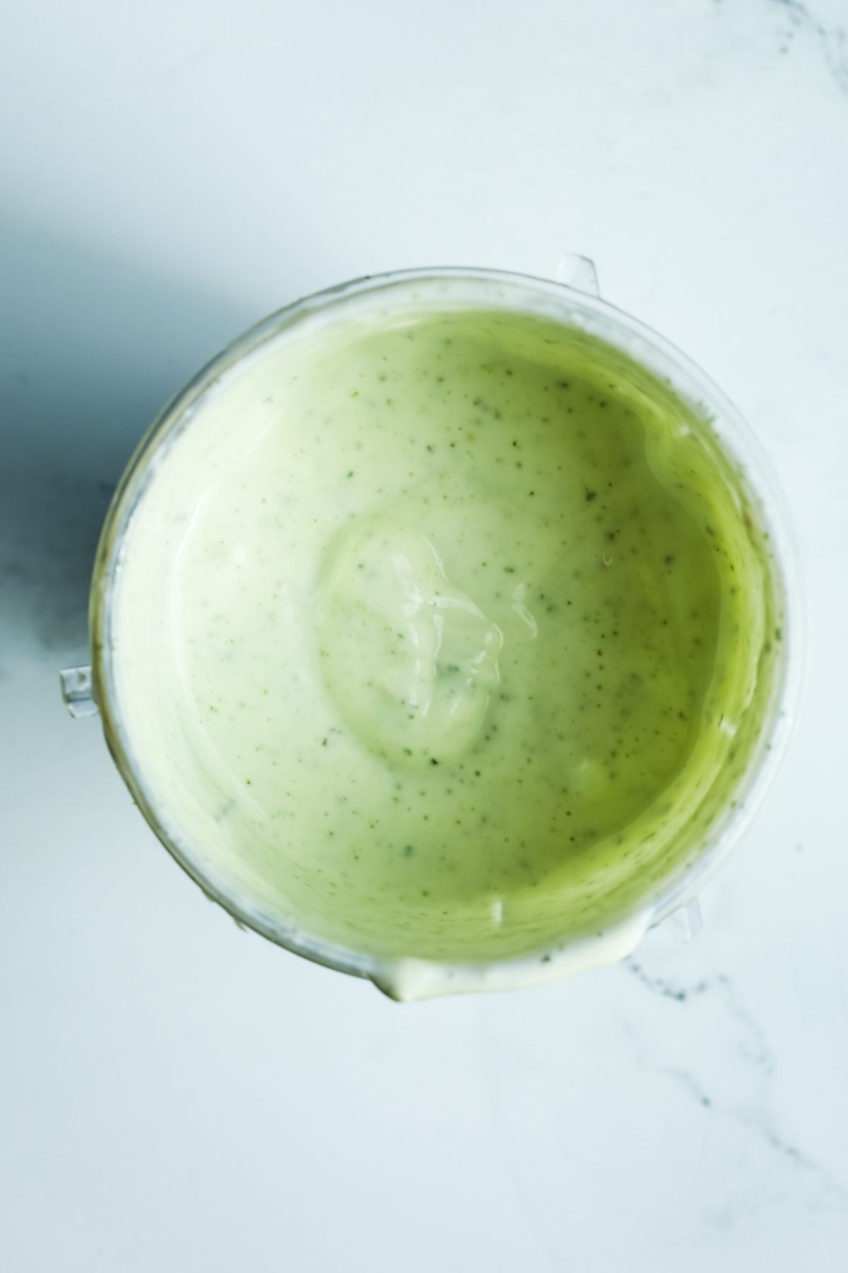 a green-hued yogurt mixture in a small blender container 