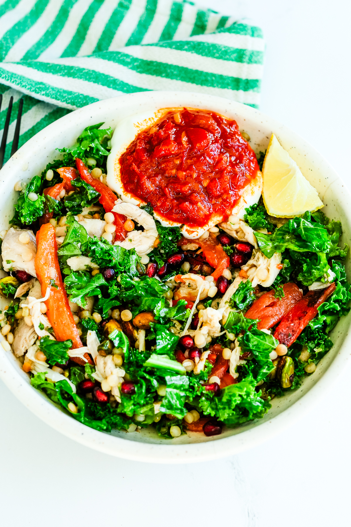Harissa Chicken bowl with a green and white striped napkin