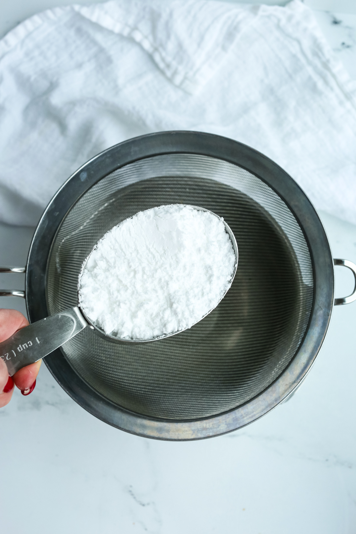 a measuring cup with powdered sugar