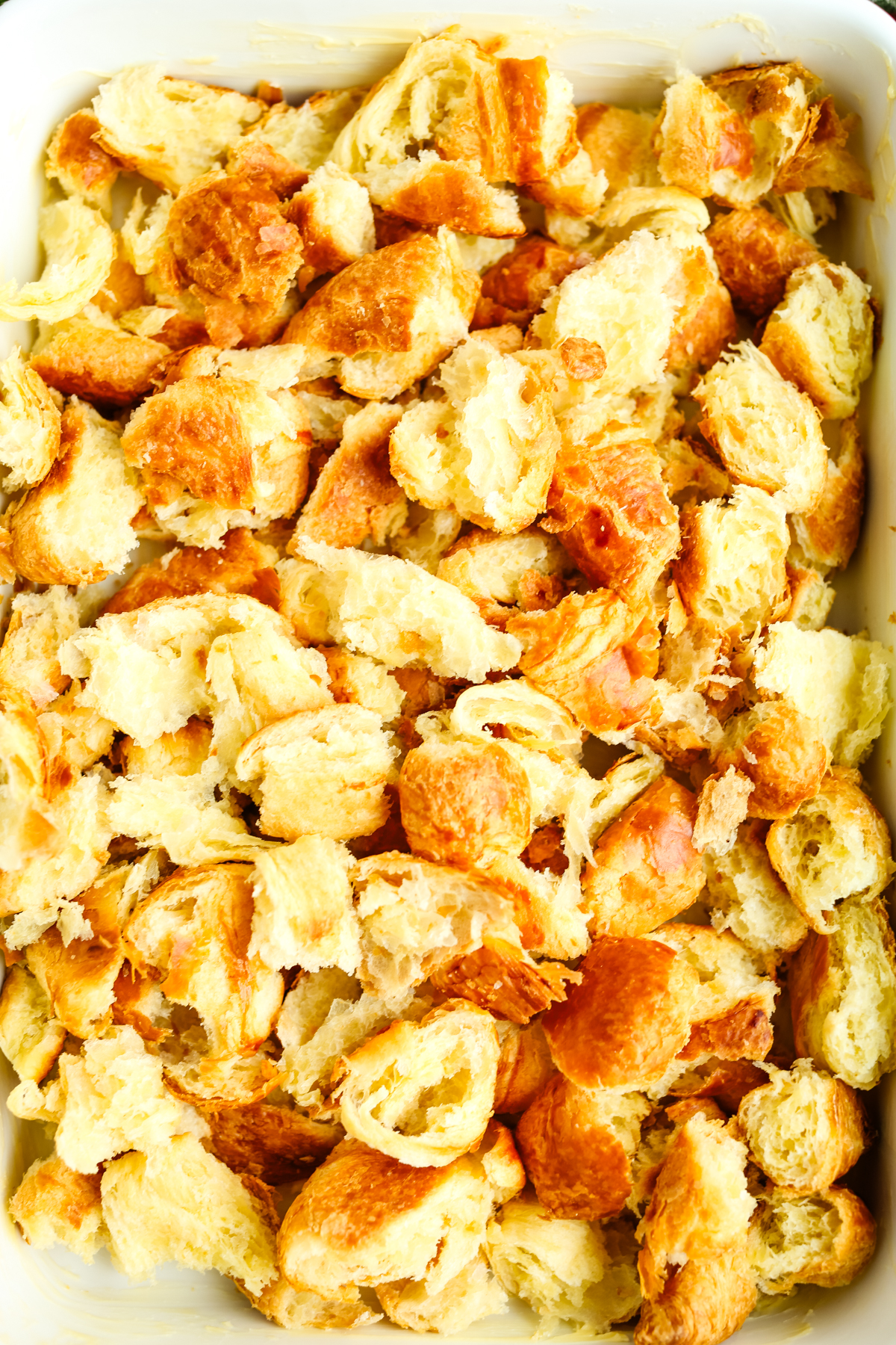torn croissant pieces in the bottom of a baking dish