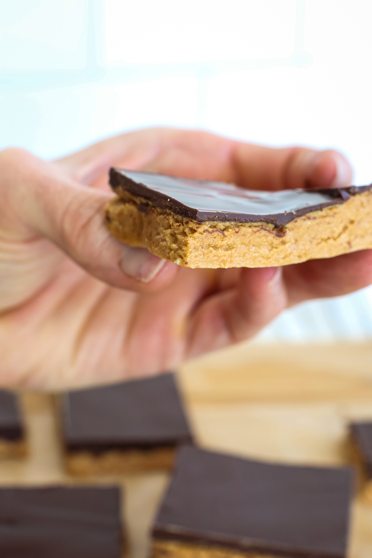 Holding a chocolate peanut butter protein bar