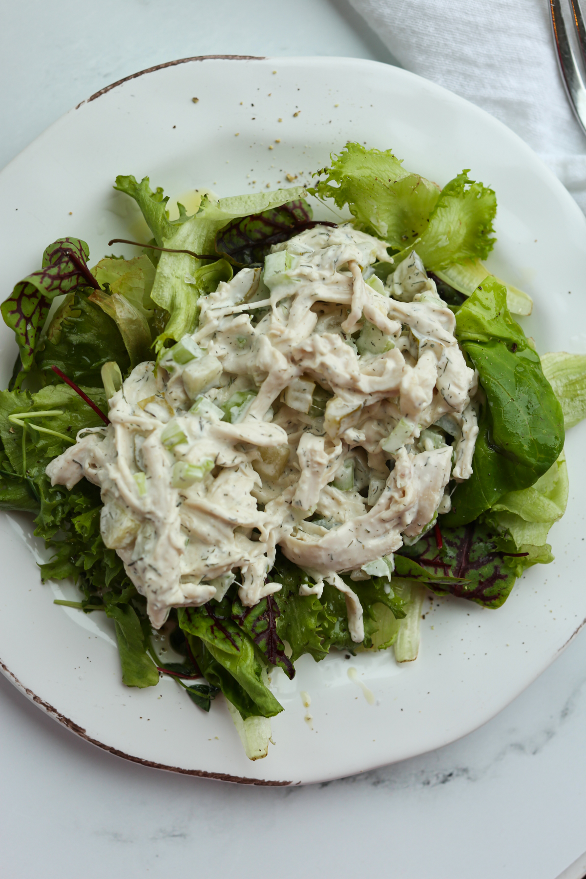 Dill Pickle Chicken Salad on a bed of lettuce on a white plate
