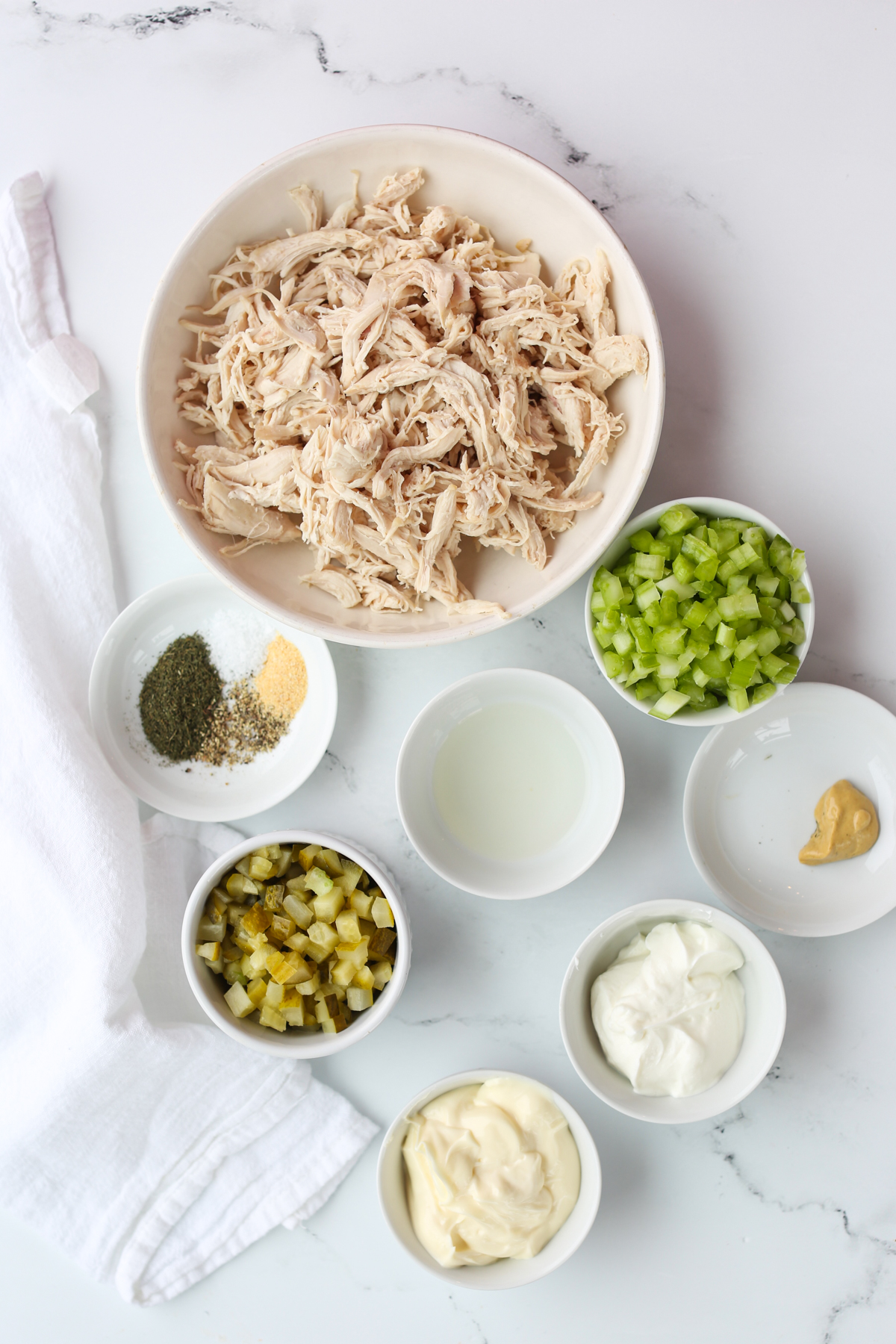ecipe ingredients in separate white bowls with a white napkin on the side 