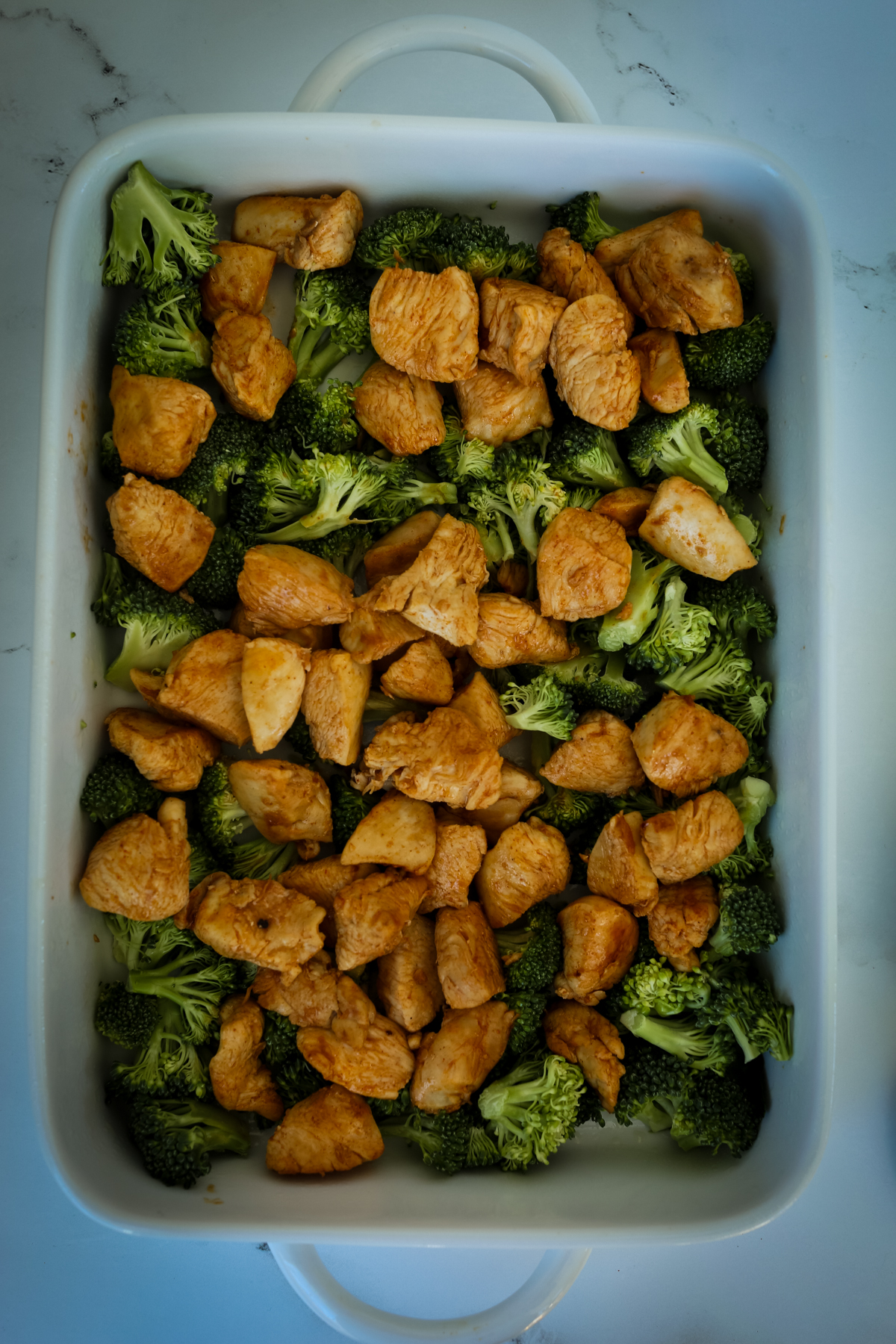 cooked chicken chunks and broccoli in casserole dish
