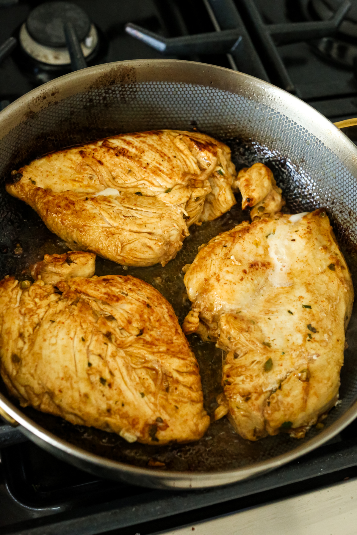 chicken breasts cooking in a skillet