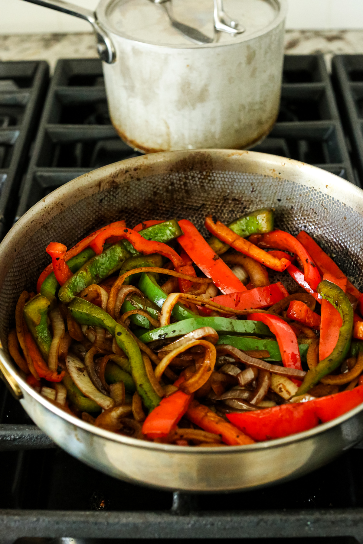 bell peppers and onions cooking in a skillet