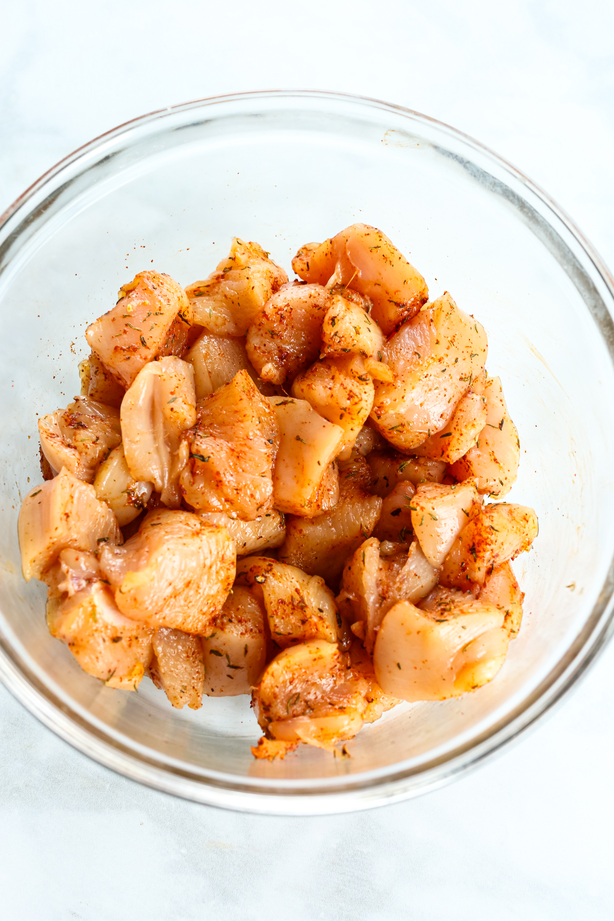 seasoned chicken chunks in a glass bowl 