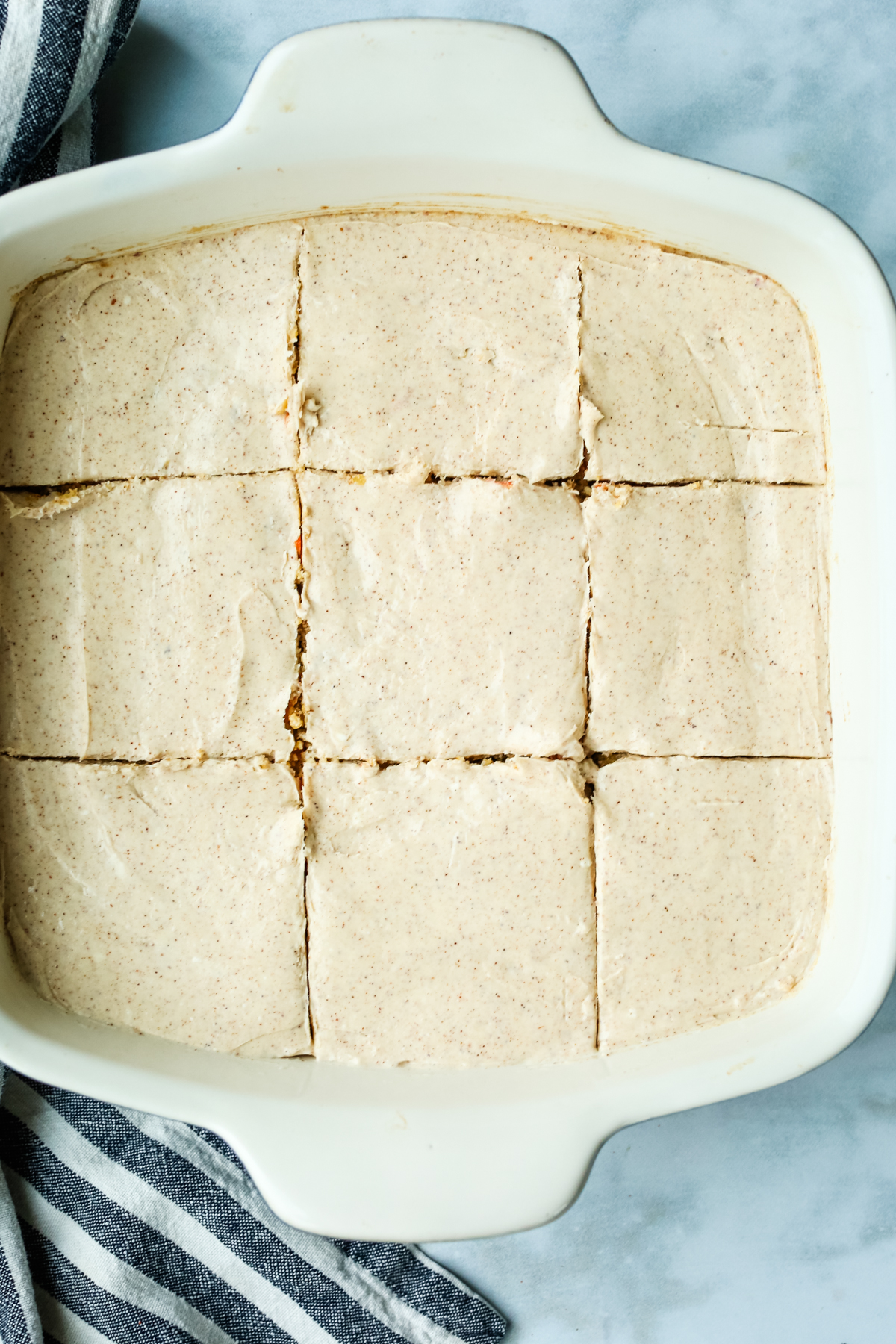 a pan of frosted baked oats cut into bars