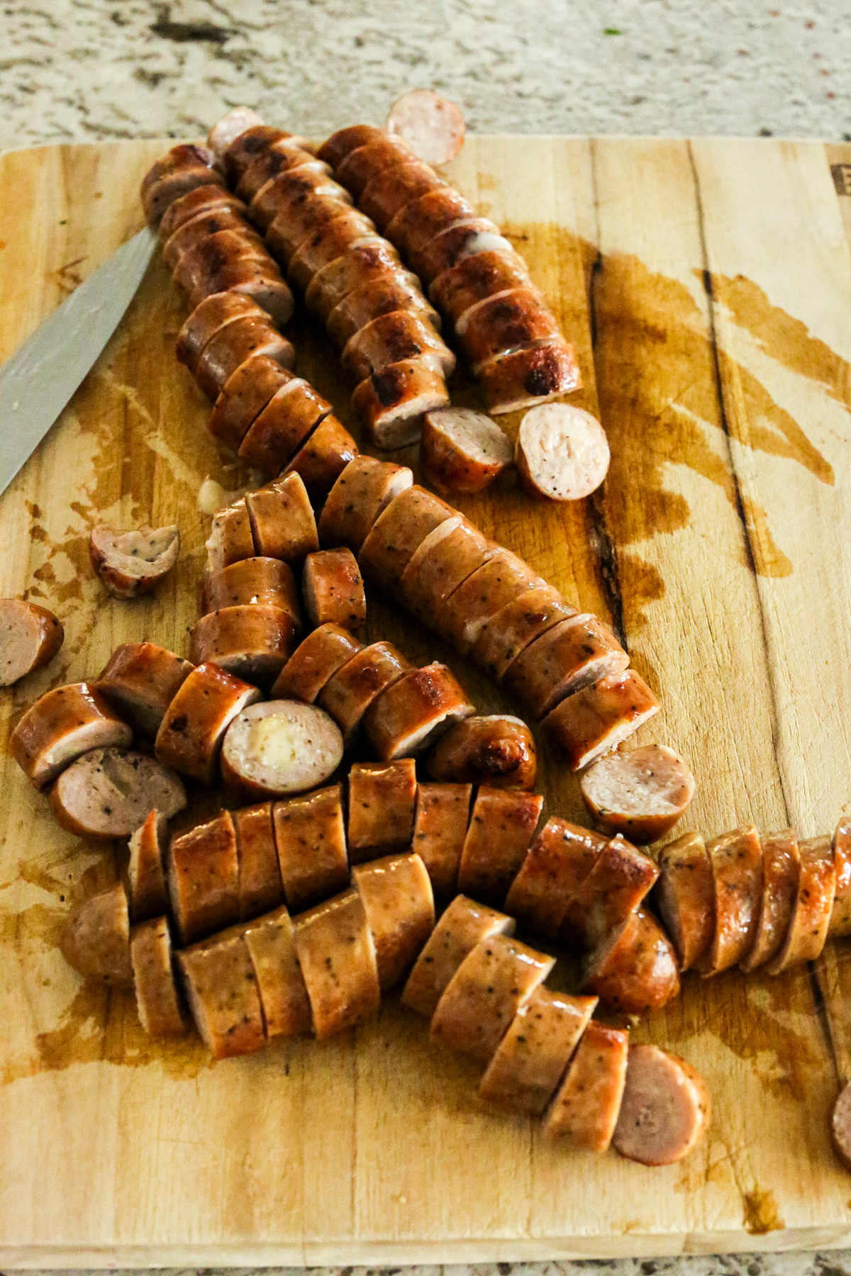 chicken sausage links sliced on a cutting board