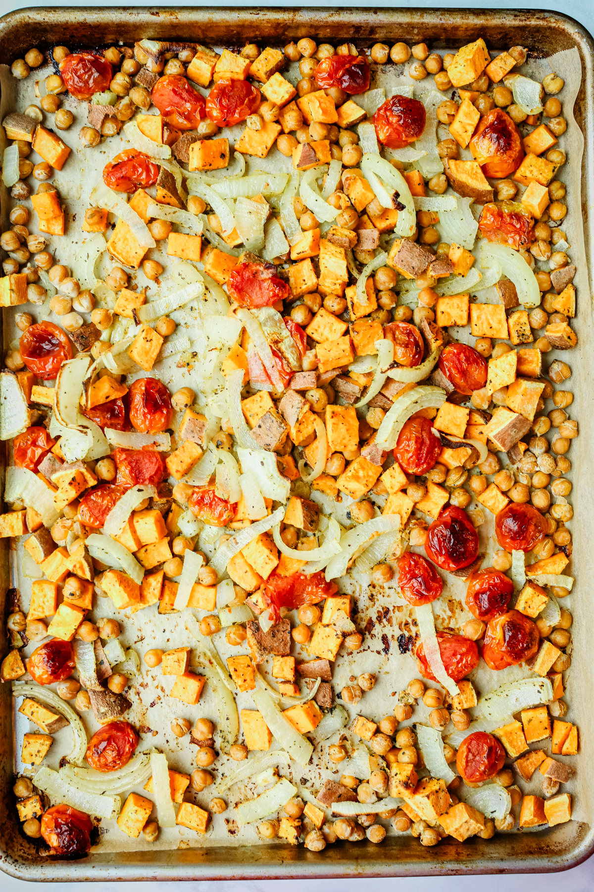roasted chickpeas, sweet potato, and onions on a baking sheet