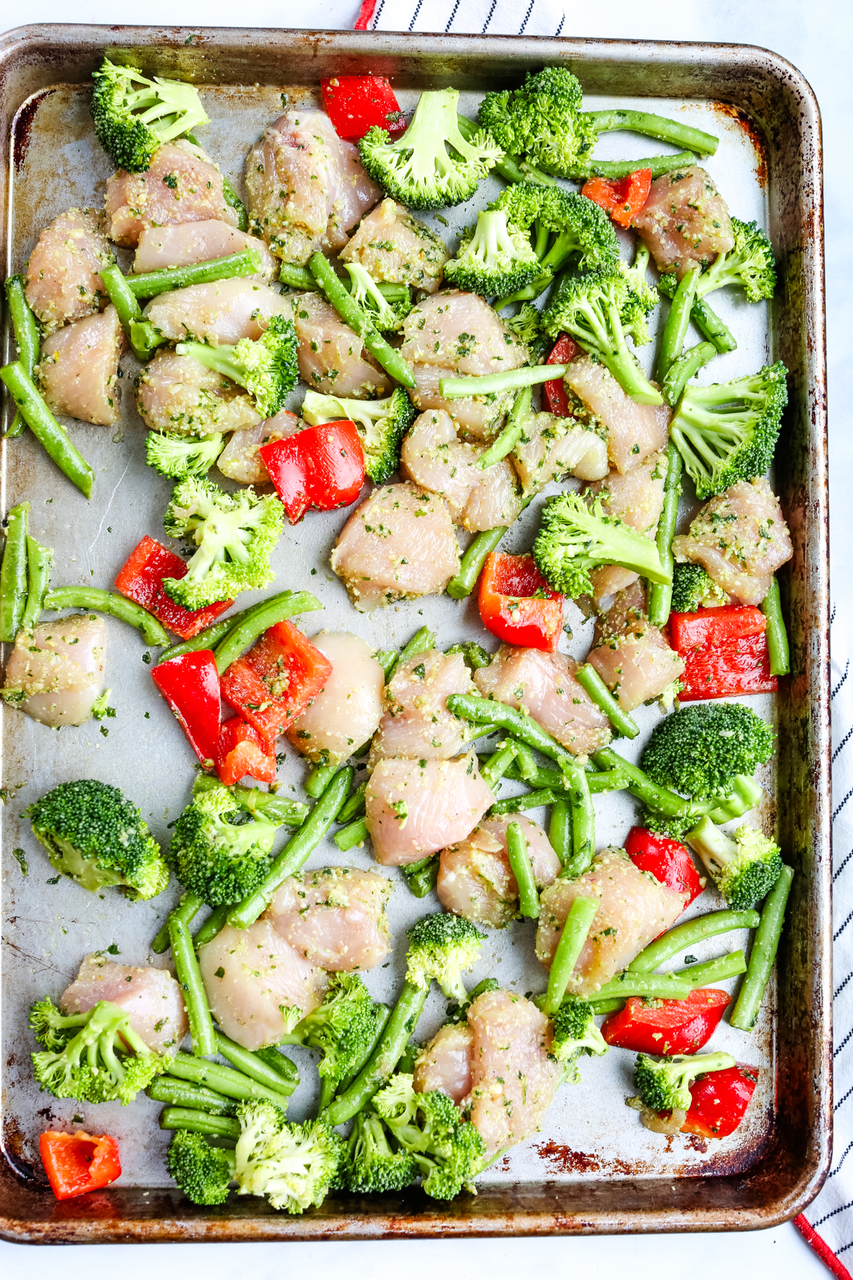 chicken and vegetables with pesto on a sheet pan