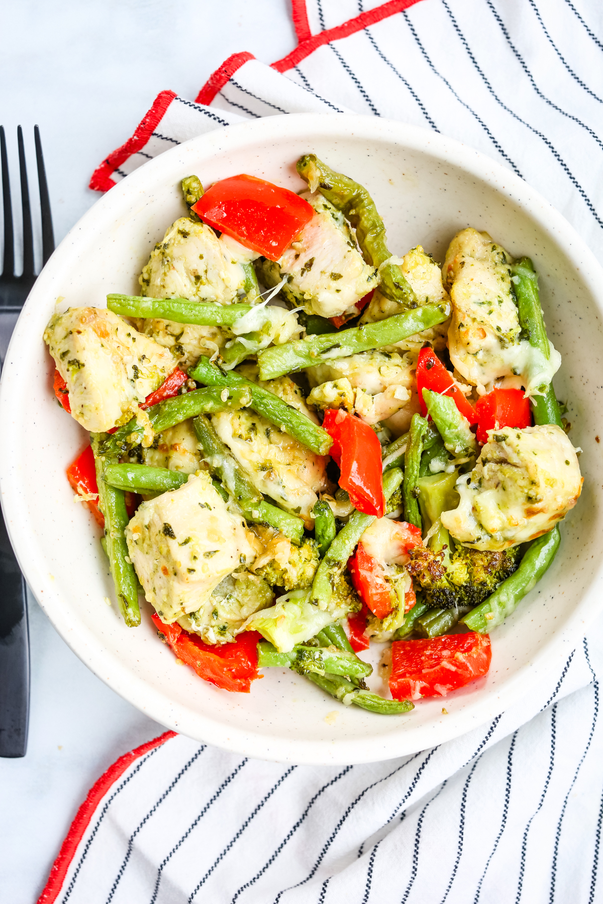 a bowl with chicken, green beans, red peppers, and broccoli