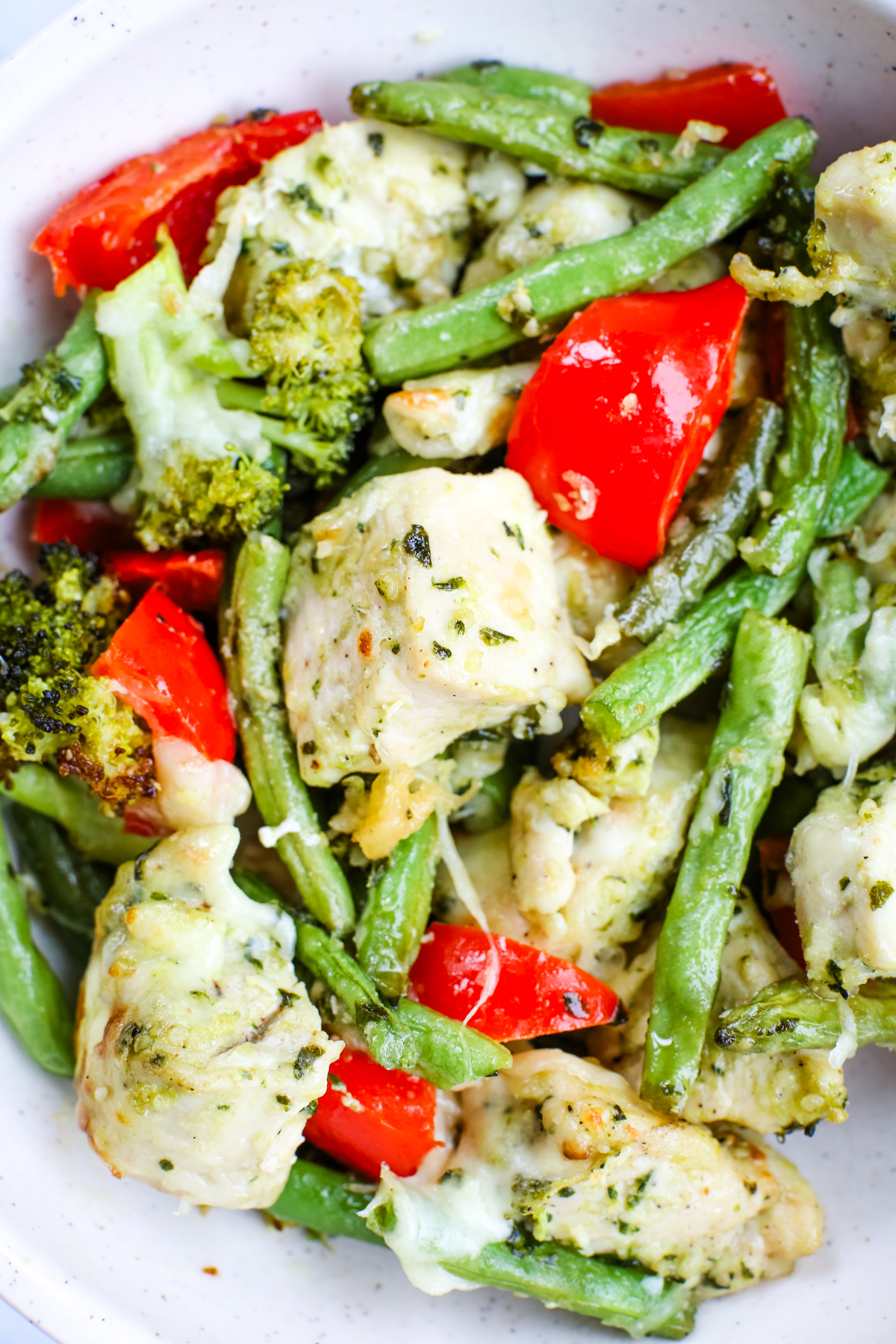 close up shot of sheet pan pesto chicken and vegetables recipe in a bowl