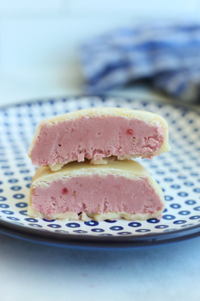 a strawberry protein bite cut in half, stacked on top of each other