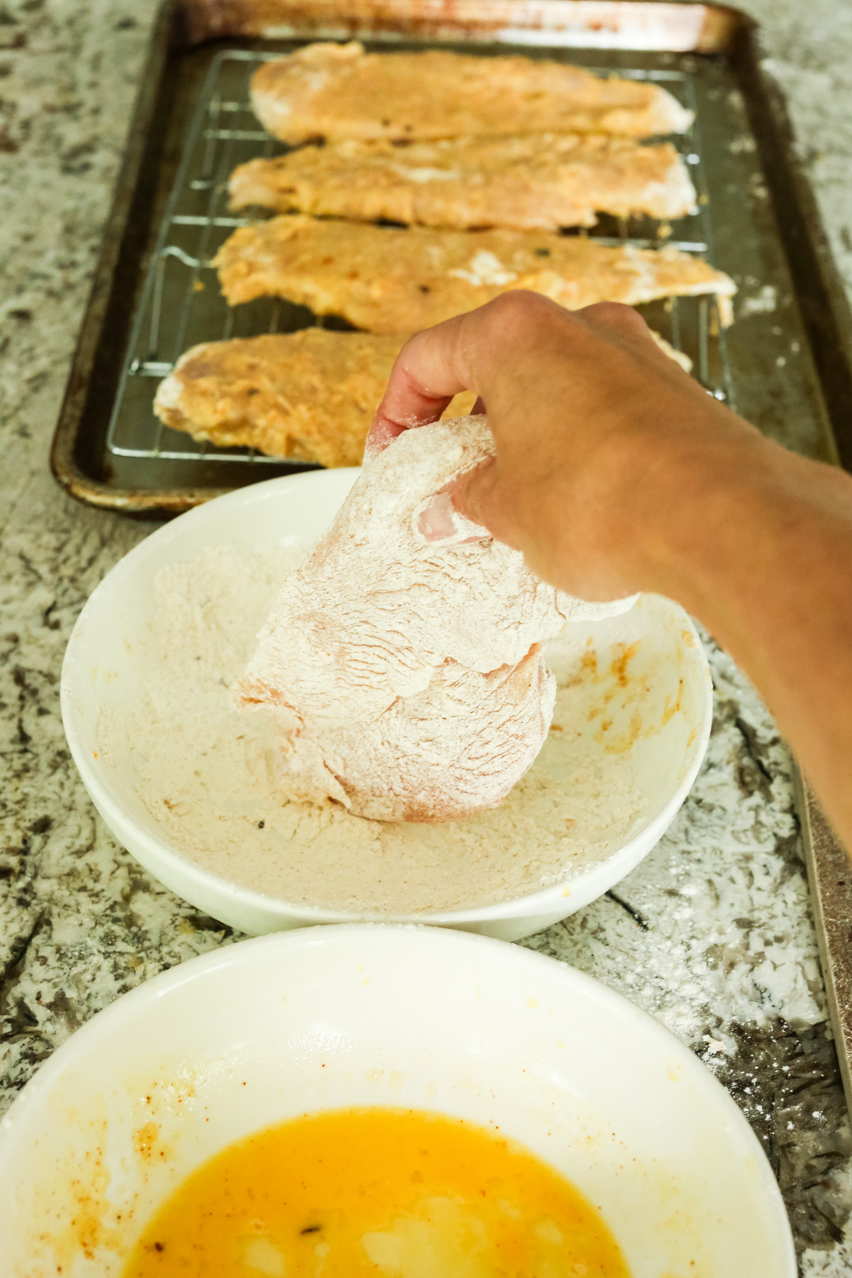 dredging a chicken breast with flour