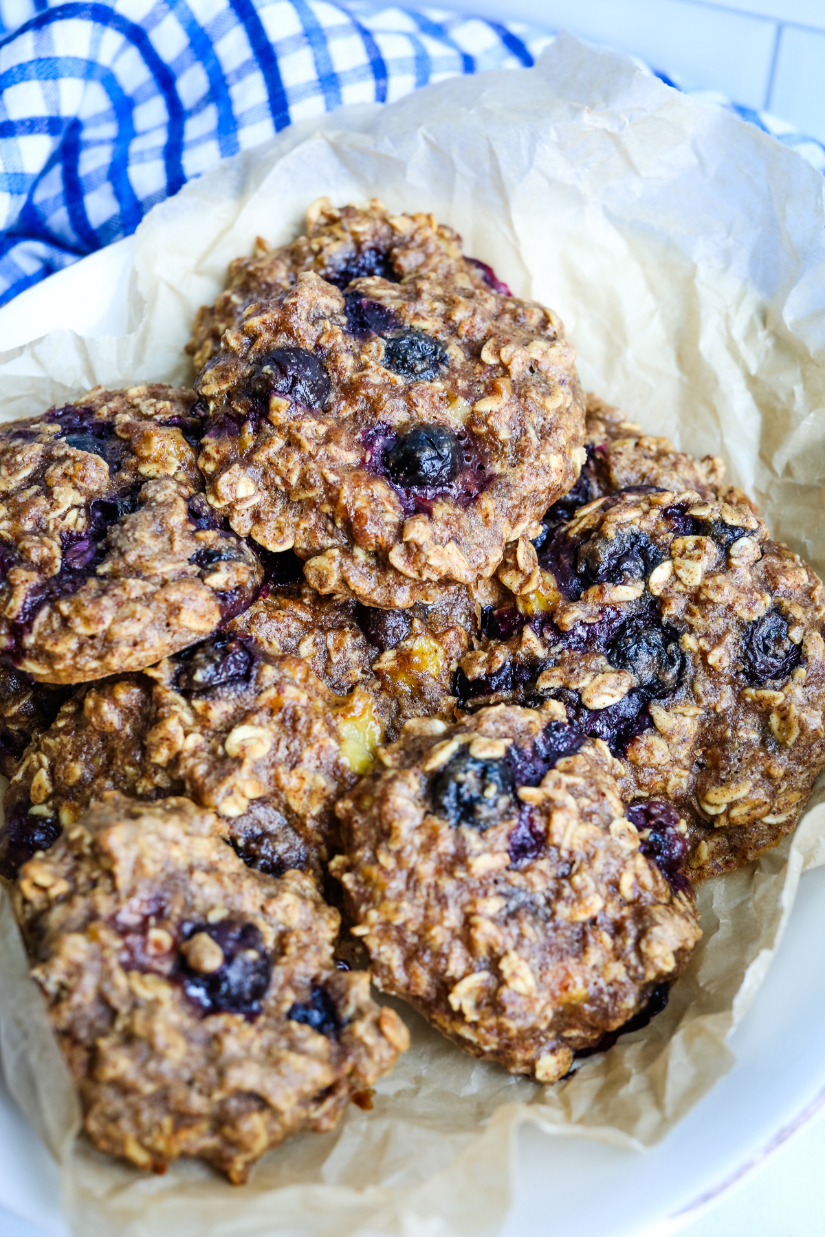 a pile of blueberry cookies in a bowl lined with parchment paper 