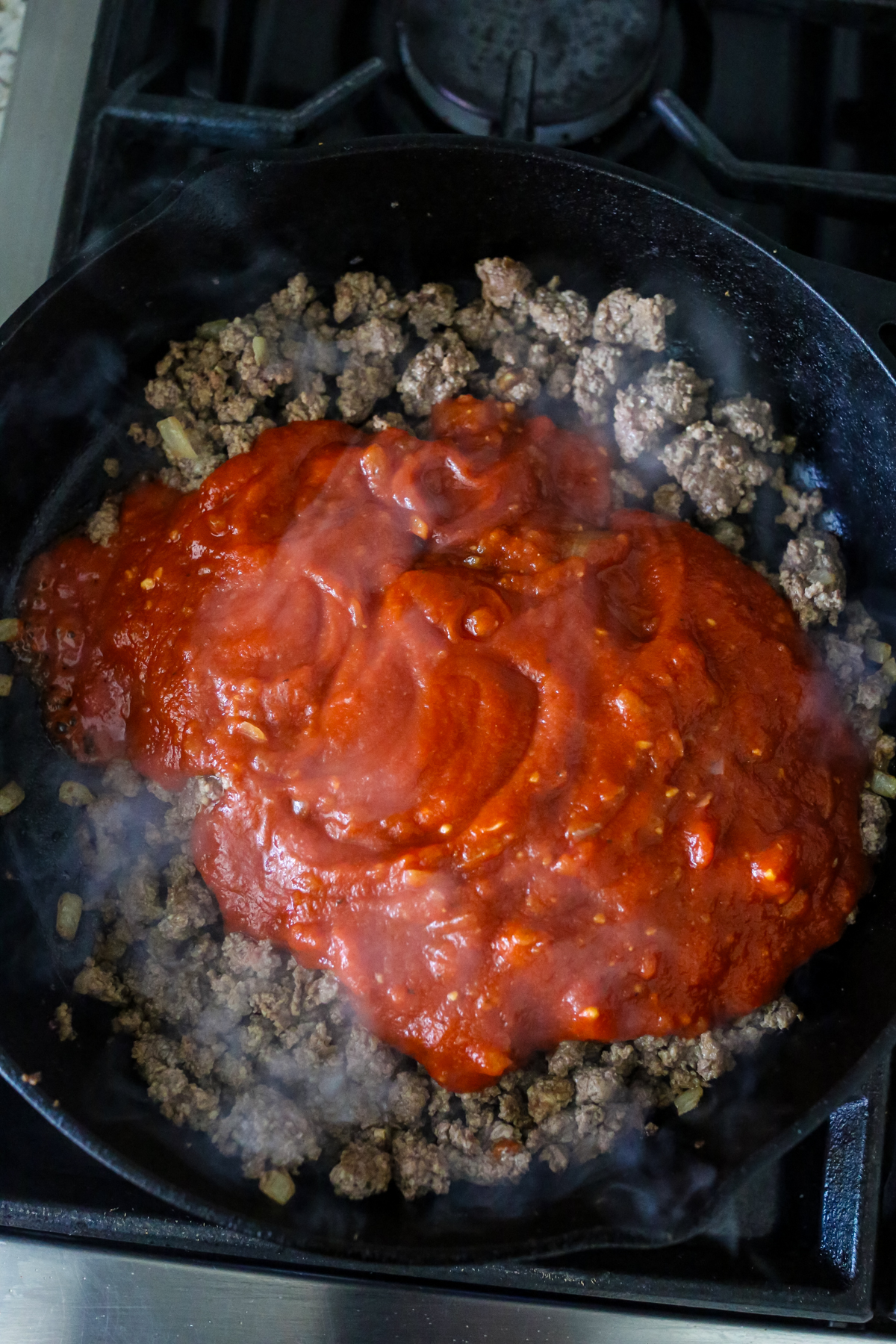 Marinara sauce on top of browned ground beef