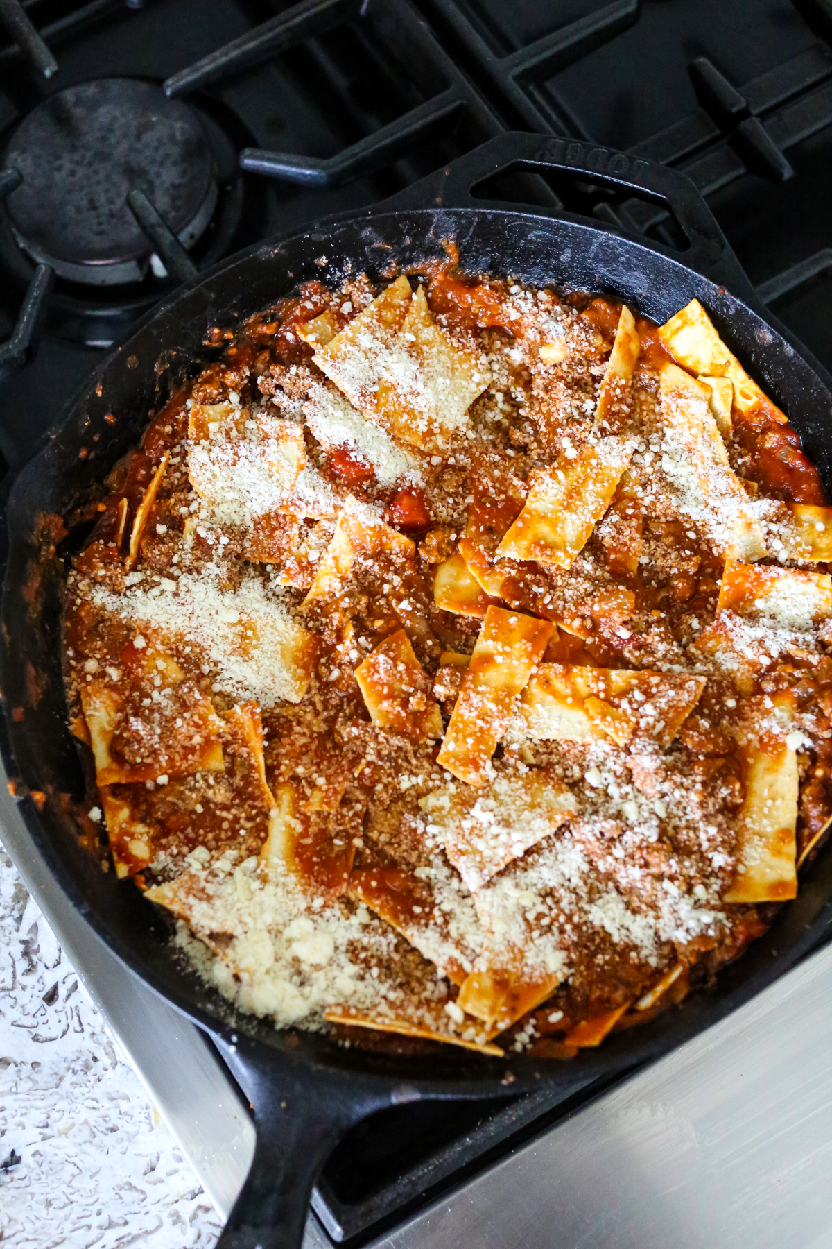 parmesan cheese sprinkled on uncooked lasagna 