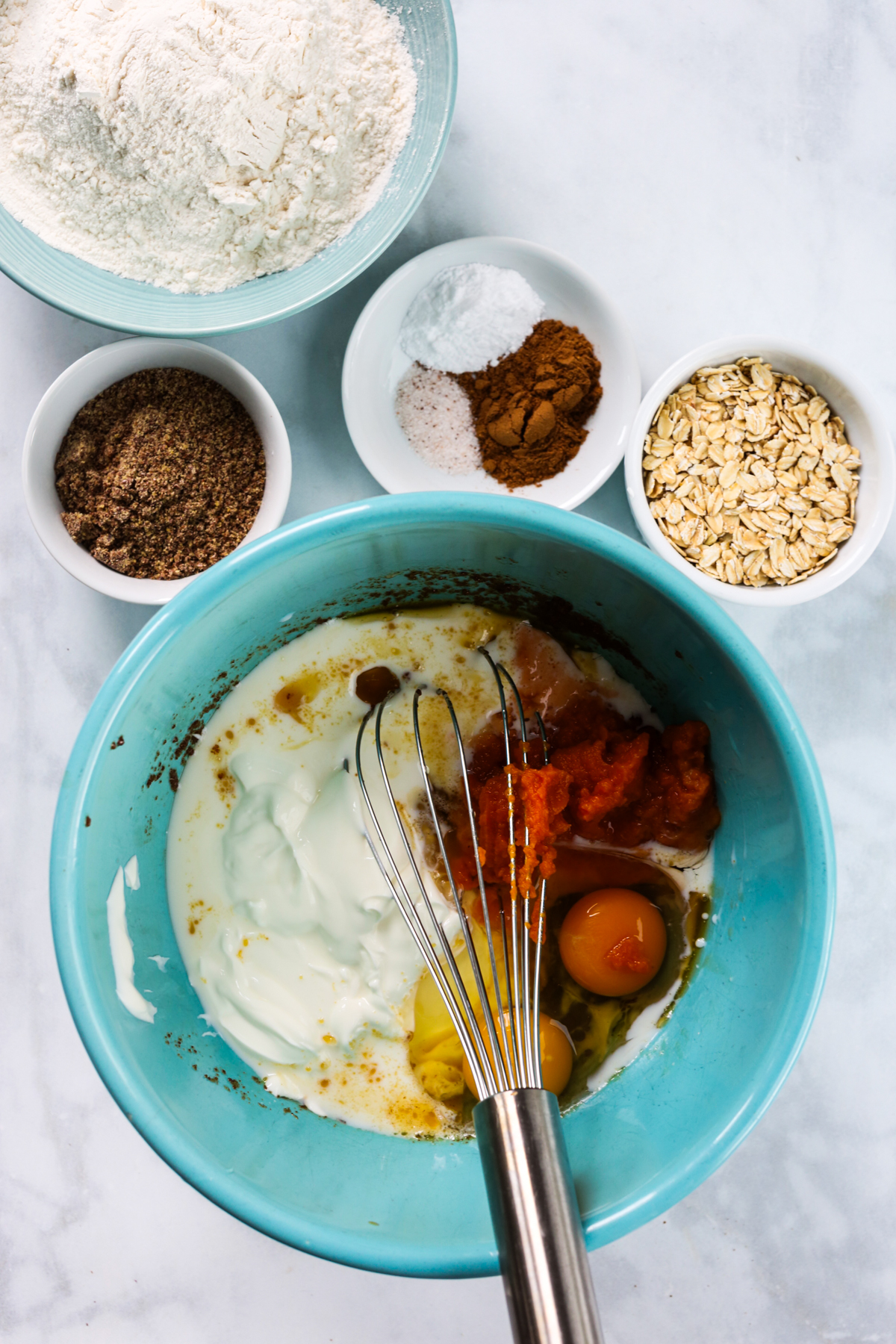 adding more wet ingredients and whisking them together 