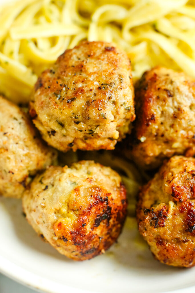 Turkey meatballs close up with fettuccine with pesto