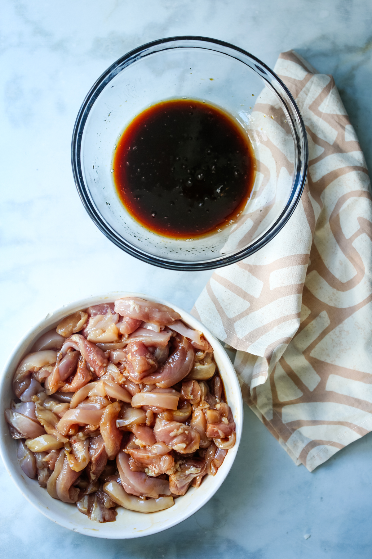 marinating chicken pieces in one bowl, sauce in another bowl 