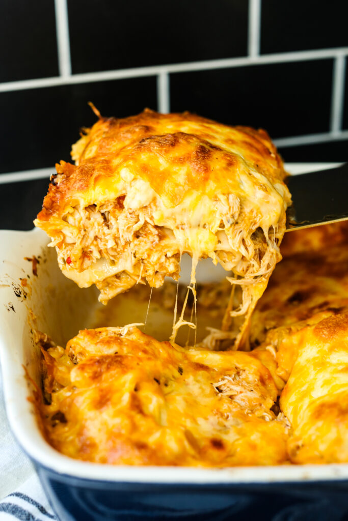 chicken taco casserole being scooped out of the dish