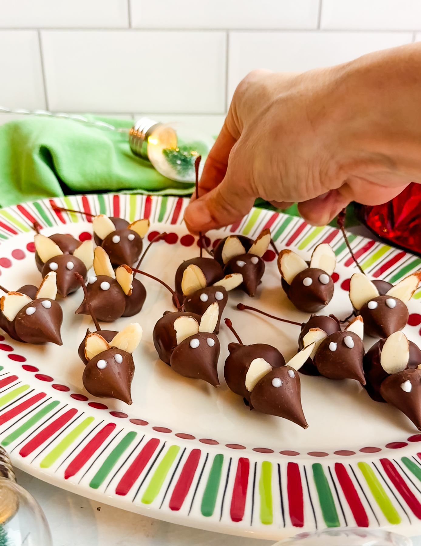 A hand grabbing a Christmas mouse by the tail 