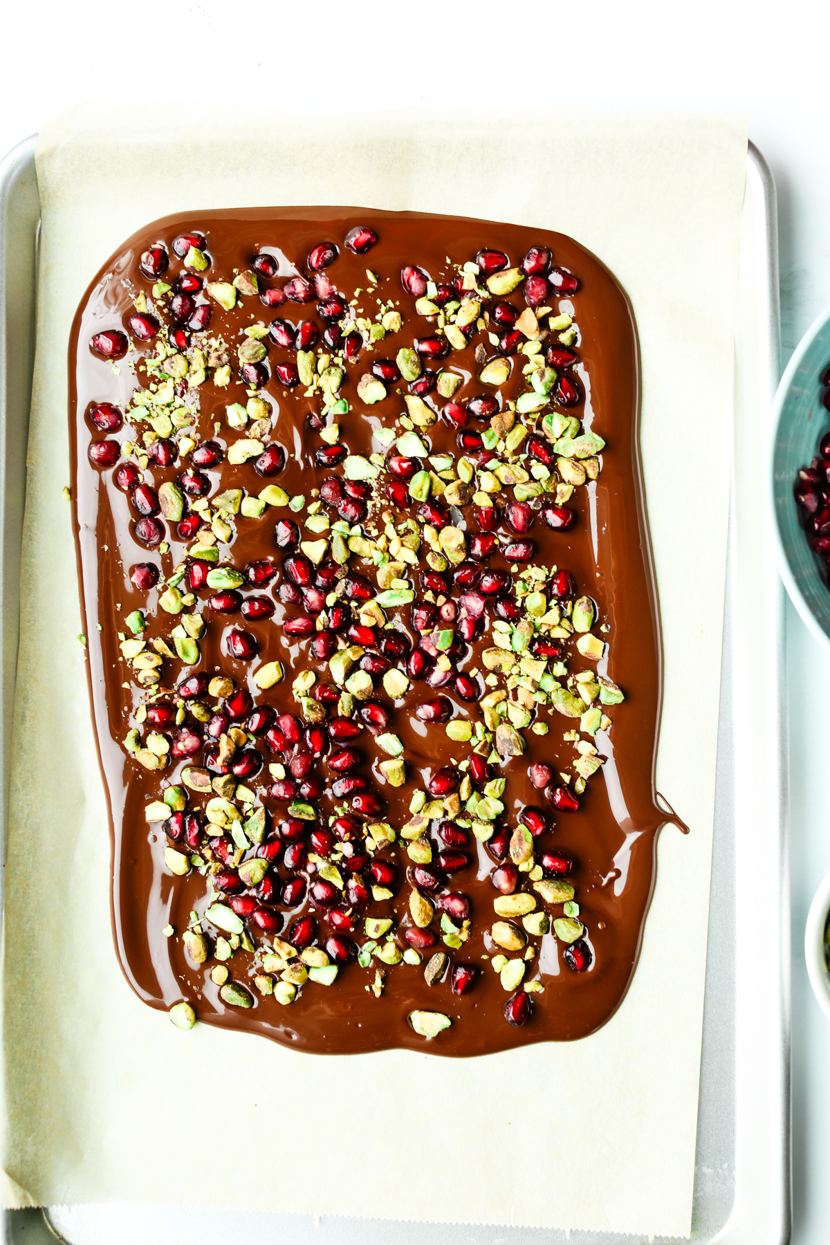 melted chocolate with pomegranate arils and chopped pistachios