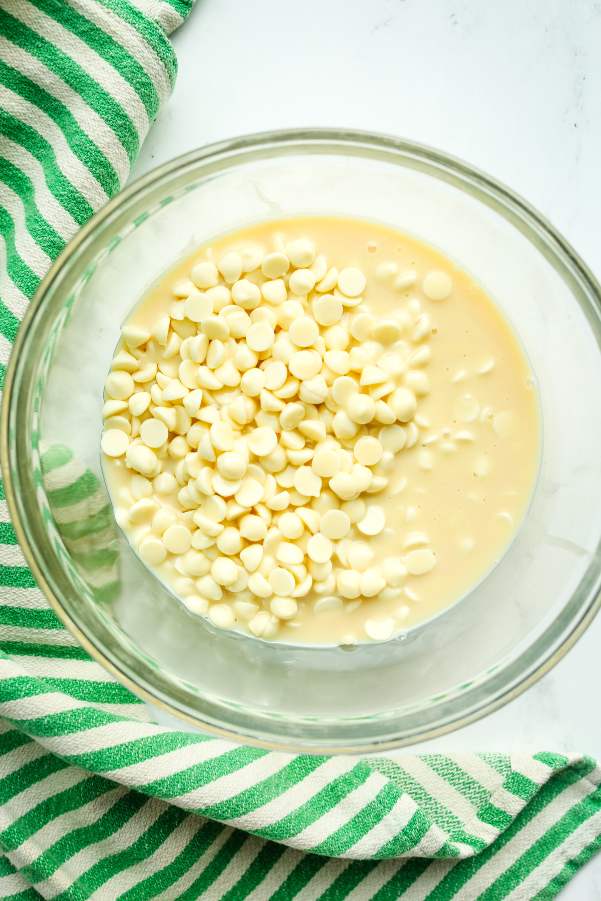 white chocolate chips and condensed milk in a bowl 