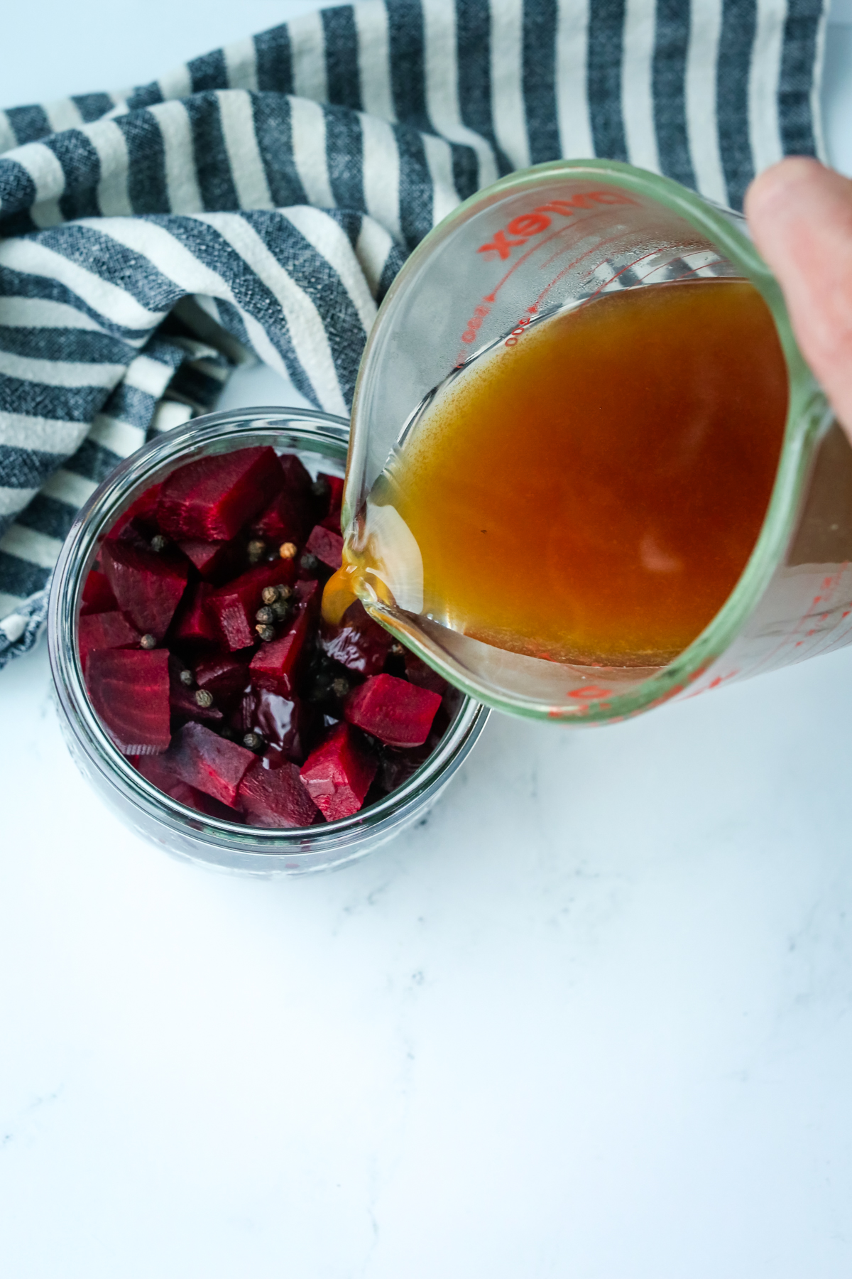 pouring hot brines on roasted beets in a jar