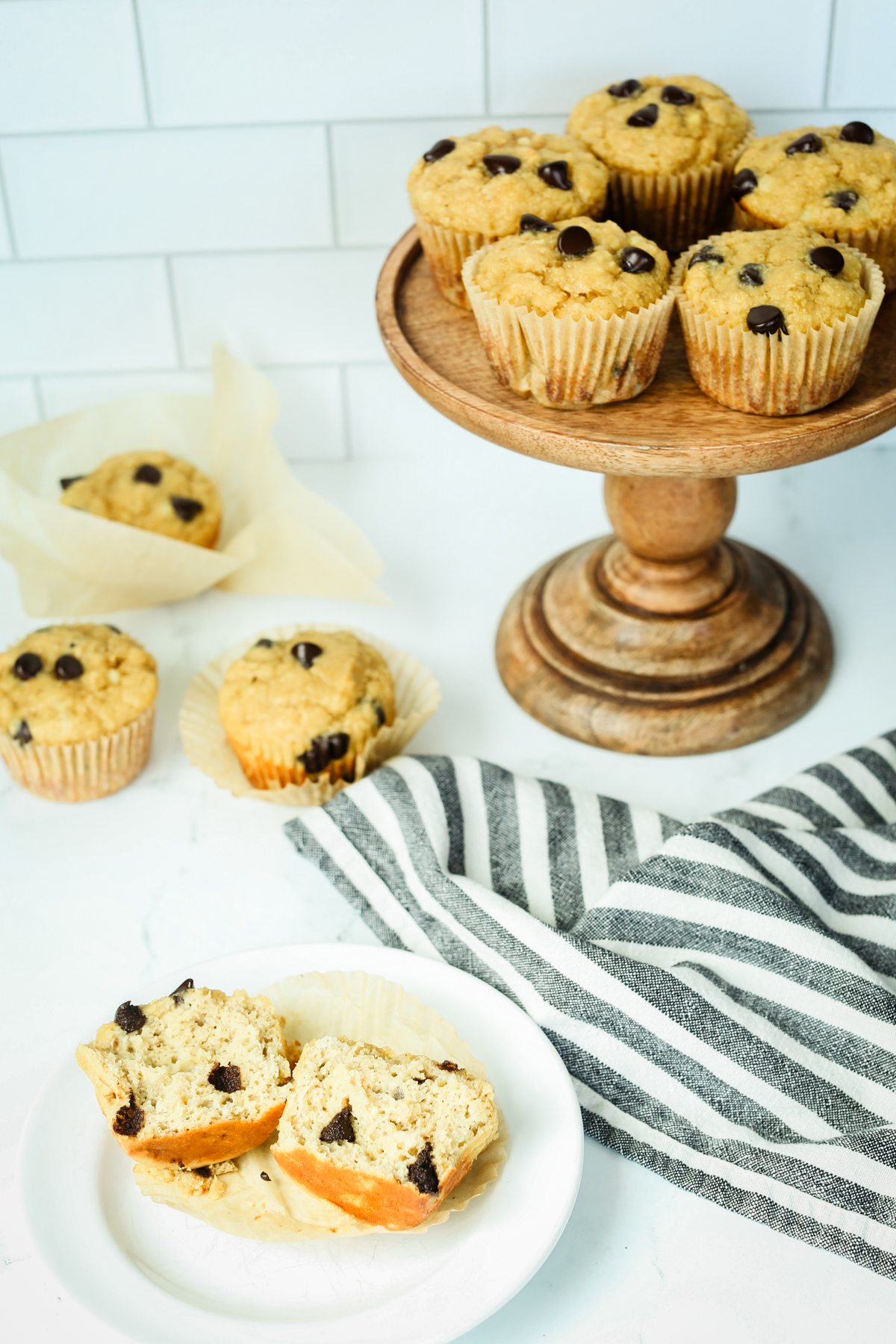 muffins arranged on a counter with one cut open on a plate