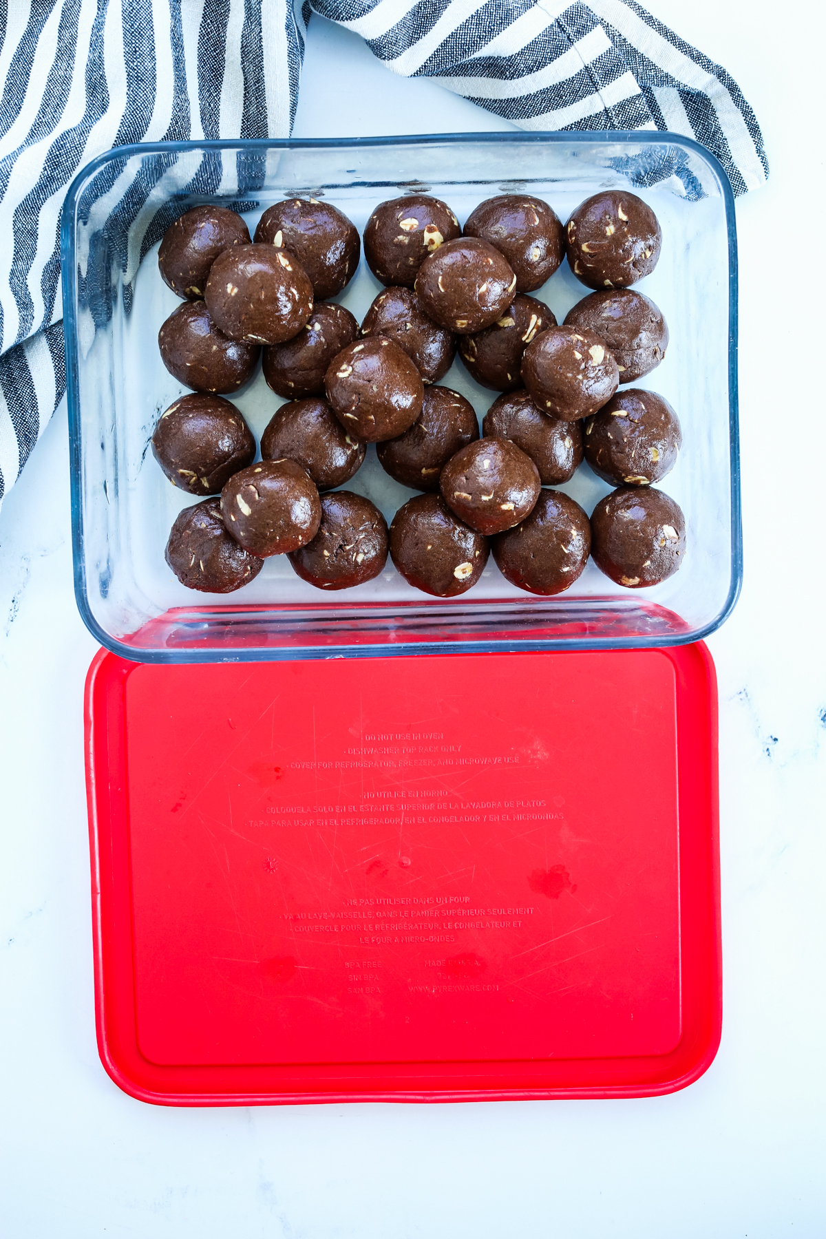 chocolate protein balls in a container to be stored
