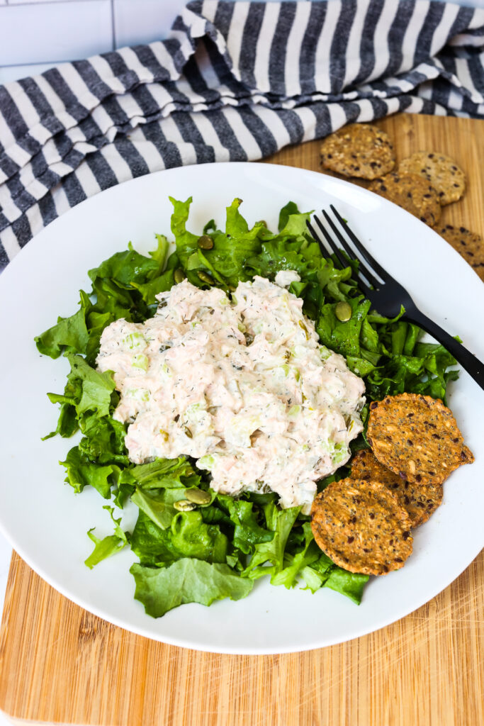 Dill pickle tuna salad on a bed of lettuce with crackers on the side