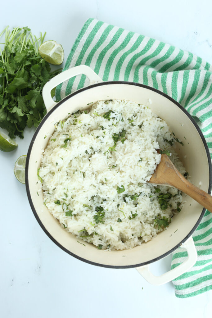 cilantro lime rice in a pot with a wooden spoon