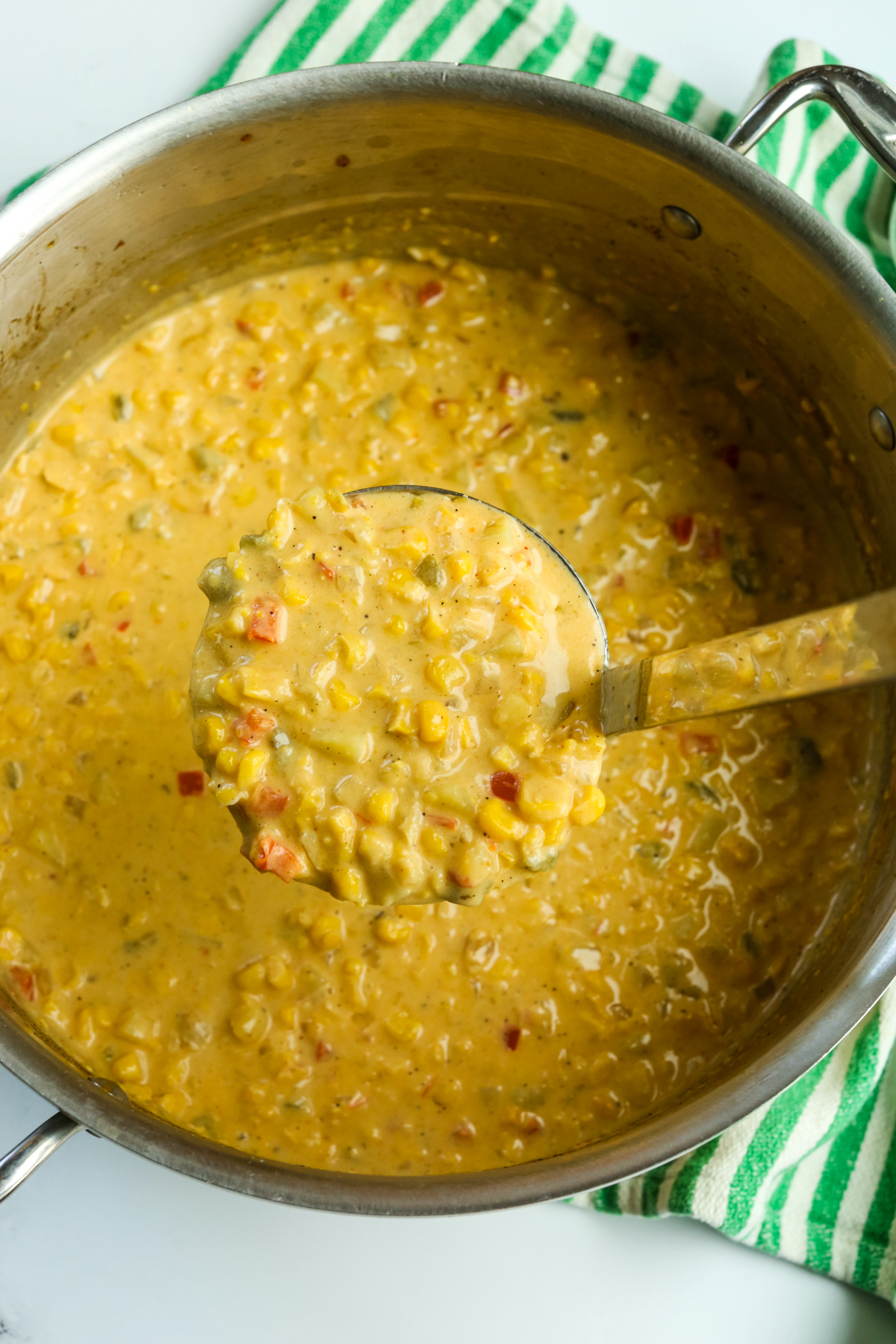 a large pot of Mexican street corn chowder with a ladle scooping out a serving 
