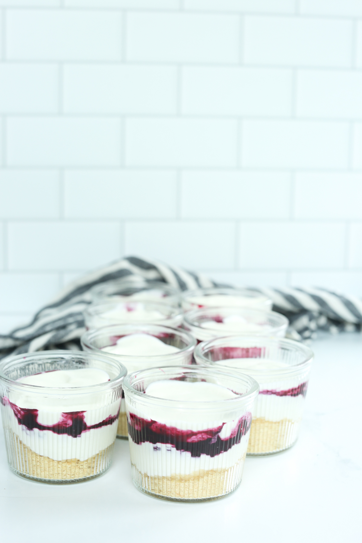 assembling the no bake lemon blueberry cheesecake parfaits in glass jars