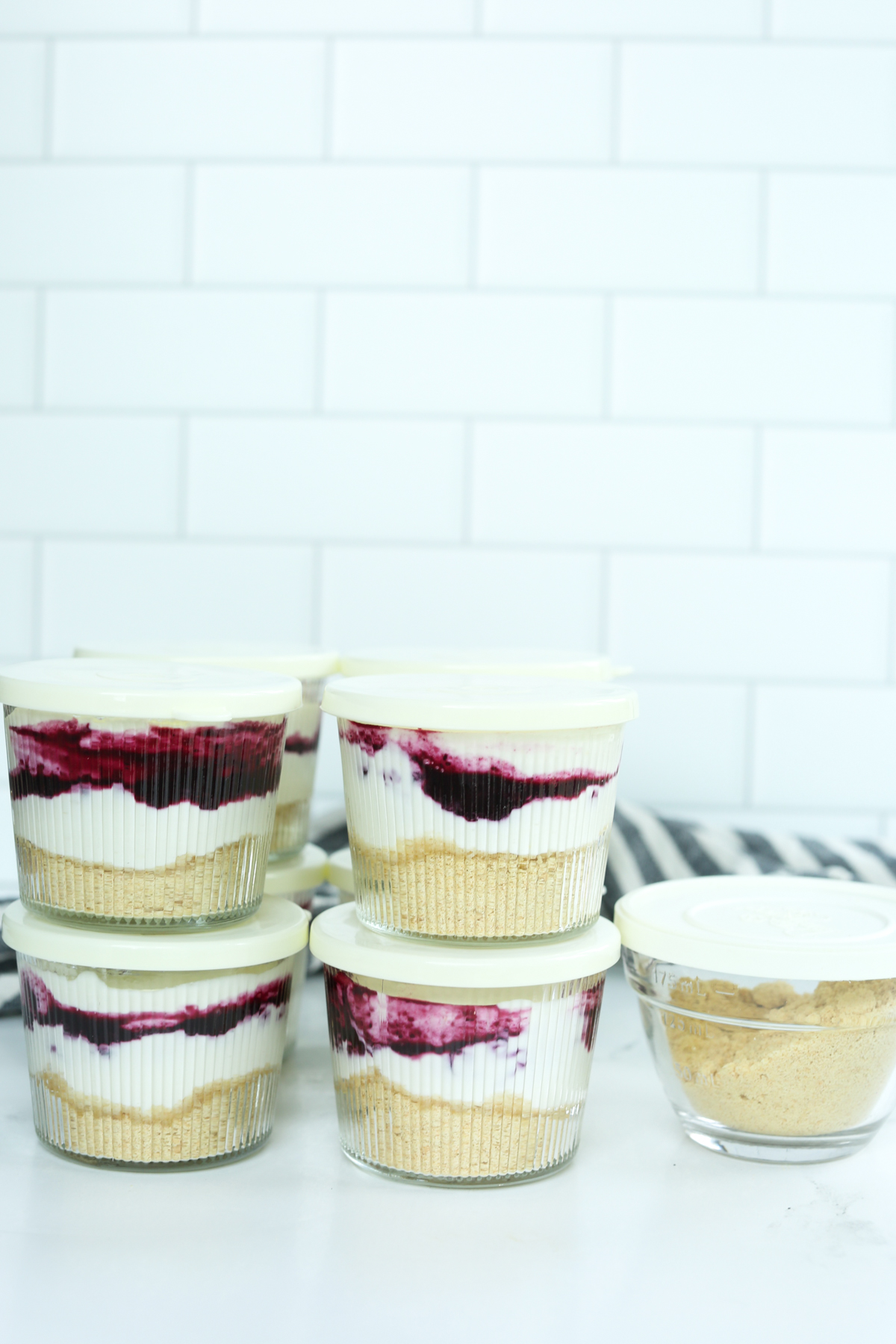 small glass jars with the dessert inside and lids on top, ready to be stored in the refrigerator. 