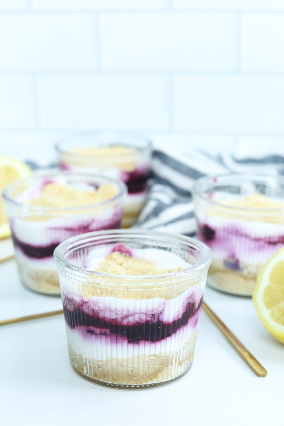 no bake lemon blueberry cheesecake parfaits in small glass jars on the table 